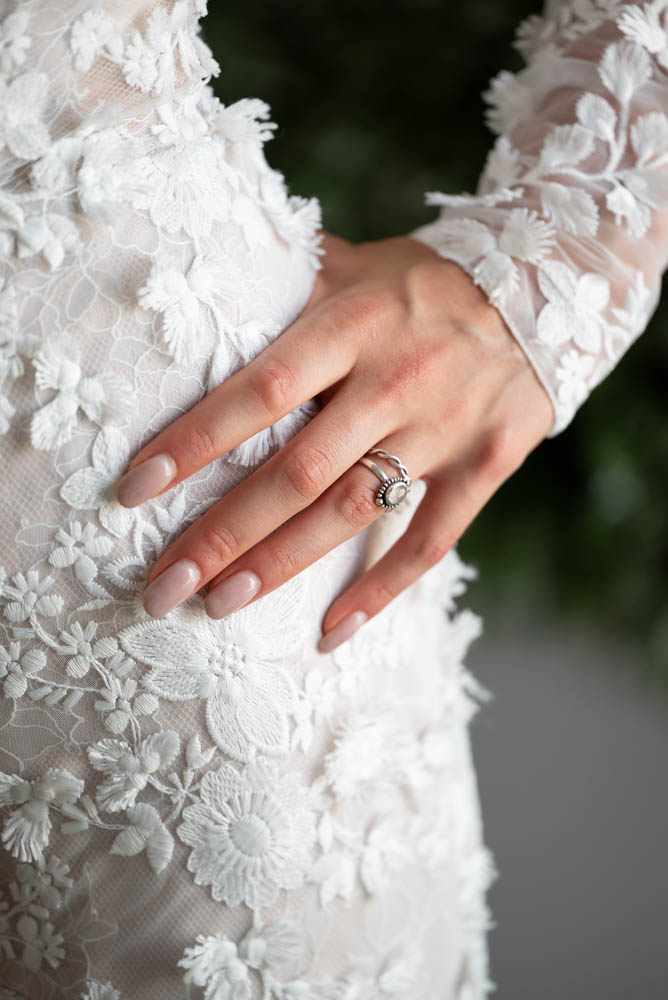 Brides hand on hip showing engagement ring and wedding band