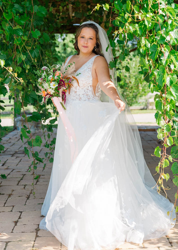 Full length bridal portrait with bride twirling her dress around